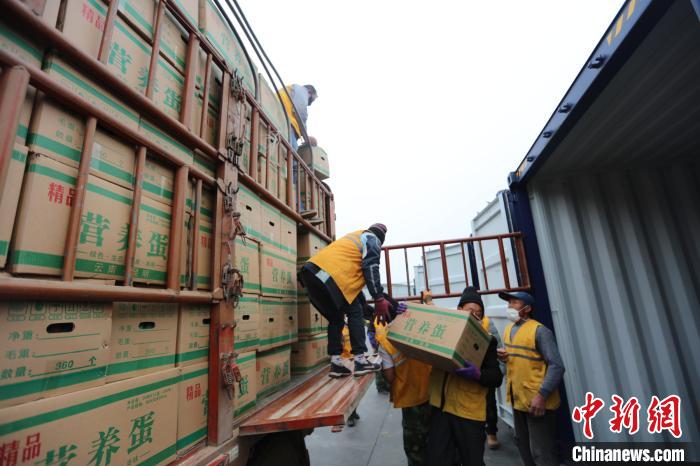 圖為鐵路裝卸作業(yè)人員正在將云南特色農(nóng)產(chǎn)品裝入集裝箱?！詈?攝