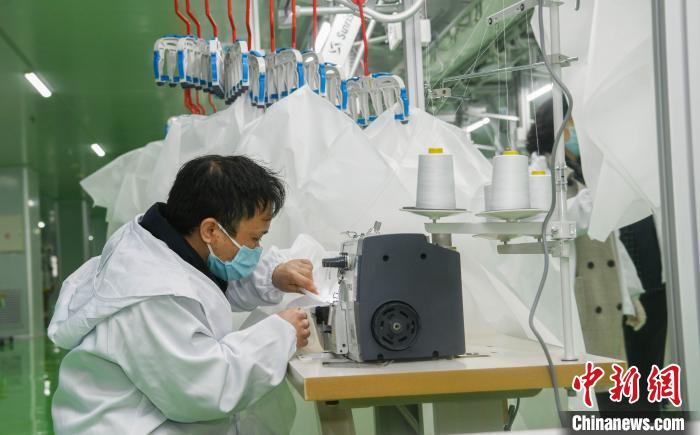 工人生產(chǎn)防護(hù)服，保障抗疫物資供應(yīng)。廣安市委宣傳部供圖