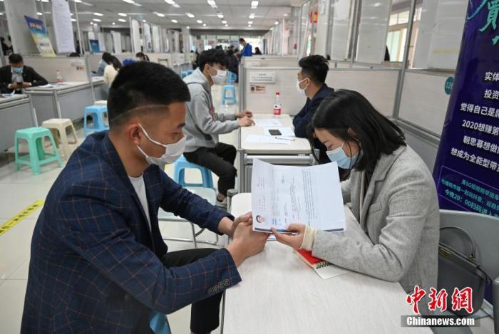 4月14日，招聘者在查看求職者簡(jiǎn)歷。<a target='_blank'  data-cke-saved- >中新社</a>記者 王剛 攝