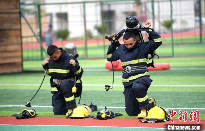 新消防員進(jìn)行穿戴空呼器展示?！⒅铱?攝