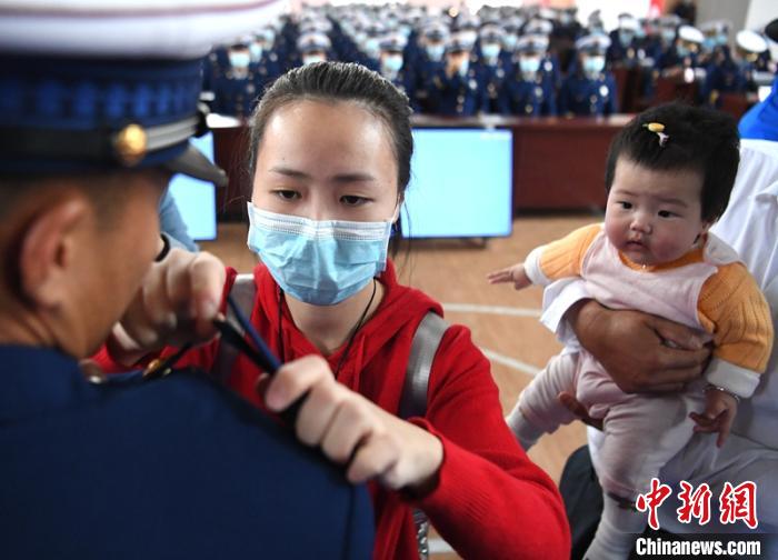 新消防員楊振的妻子彭莉與女兒現(xiàn)場(chǎng)見(jiàn)證丈夫加入“火焰藍(lán)”的神圣時(shí)刻?！⒅铱?攝