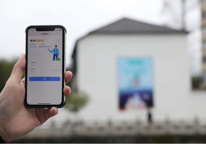 在浙江省杭州市臨安區(qū)天目山鎮(zhèn)，一名居民在“杭州健康碼”海報(bào)上掃碼申領(lǐng)個(gè)人二維碼。新華社發(fā)
