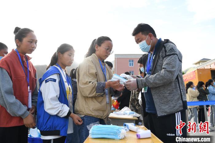 7月7日，考生在拉薩三高考點(diǎn)外領(lǐng)取口罩?！『闻罾?攝