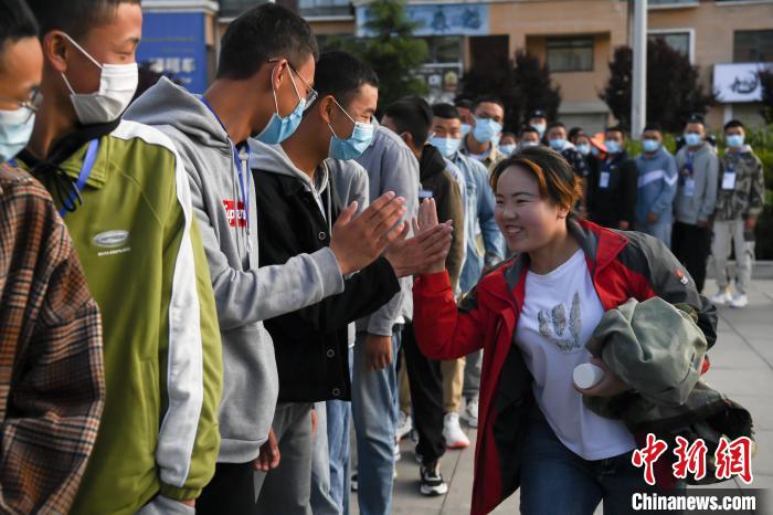 7月7日，拉薩三高考點(diǎn)外，領(lǐng)隊(duì)老師與考生擊掌鼓勁加油?！『闻罾?攝