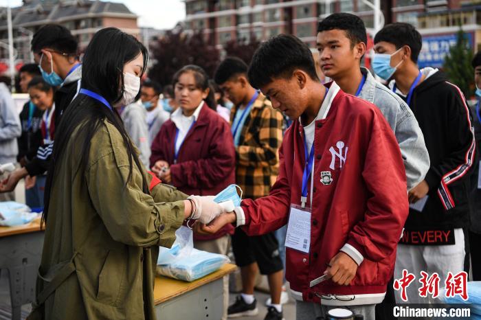 7月7日，考生在拉薩三高考點(diǎn)外測量體溫?！『闻罾?攝