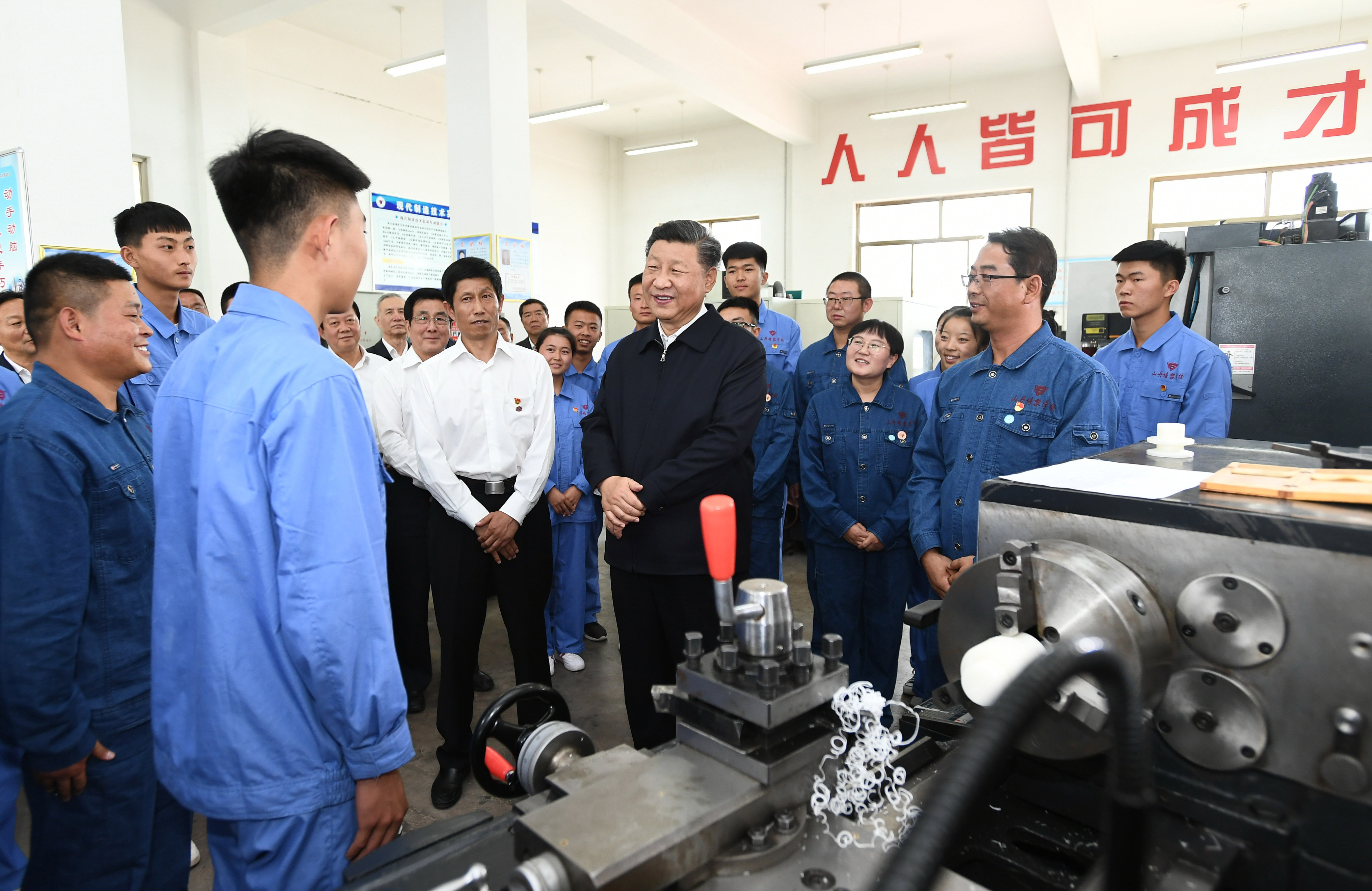 2019年8月20日，習(xí)近平在甘肅省張掖市山丹培黎學(xué)?，F(xiàn)代制造技術(shù)實(shí)訓(xùn)室，觀看職業(yè)技能實(shí)訓(xùn)，同師生親切交流。