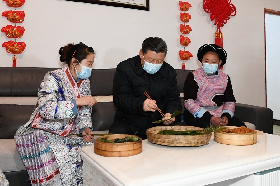 2021年2月3日下午，習近平在貴州畢節(jié)市黔西縣新仁苗族鄉(xiāng)化屋村苗族村民趙玉學家，同一家人邊聊家常邊制作當?shù)貍鹘y(tǒng)節(jié)日食品黃粑。新華社記者 李學仁 攝